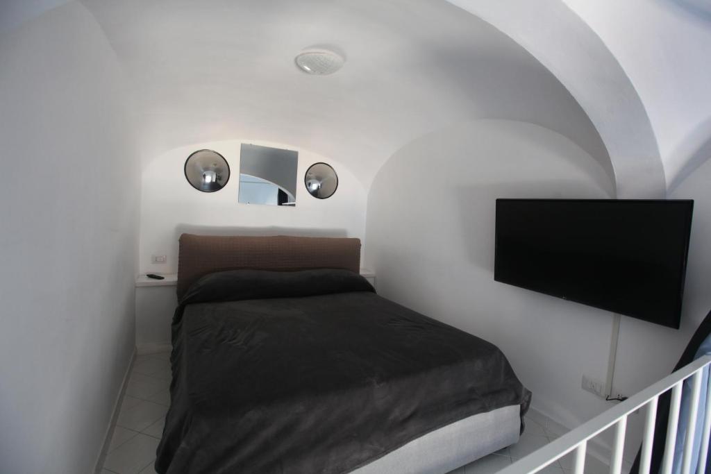 伊斯基亚Rd Guest house的一间卧室配有一张床和一台平面电视
