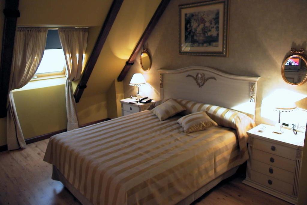 贝纳文特圣地亚哥酒店的一间卧室设有一张大床和两个床头柜