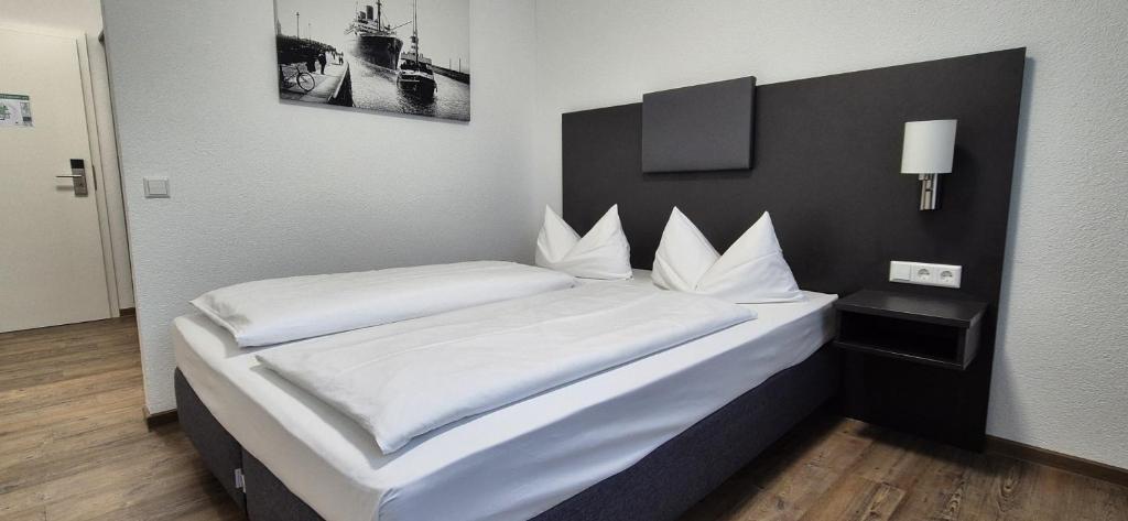 格平根Melvi Hotel Göppingen的一间卧室配有两张带白色床单的床