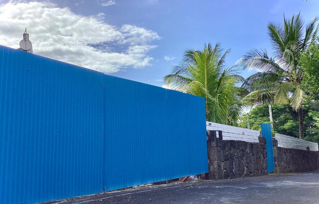 托舵道斯Original Villa的后面有一堵蓝墙,上面有棕榈树