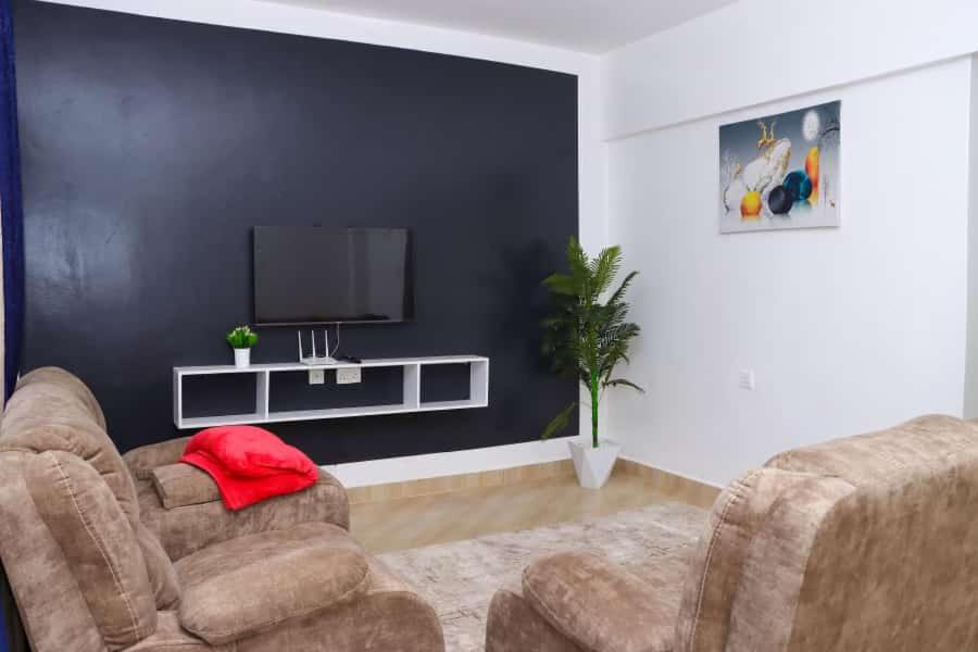 NyahururuLulu Stays 2 Bedroom的客厅配有2把椅子和平面电视