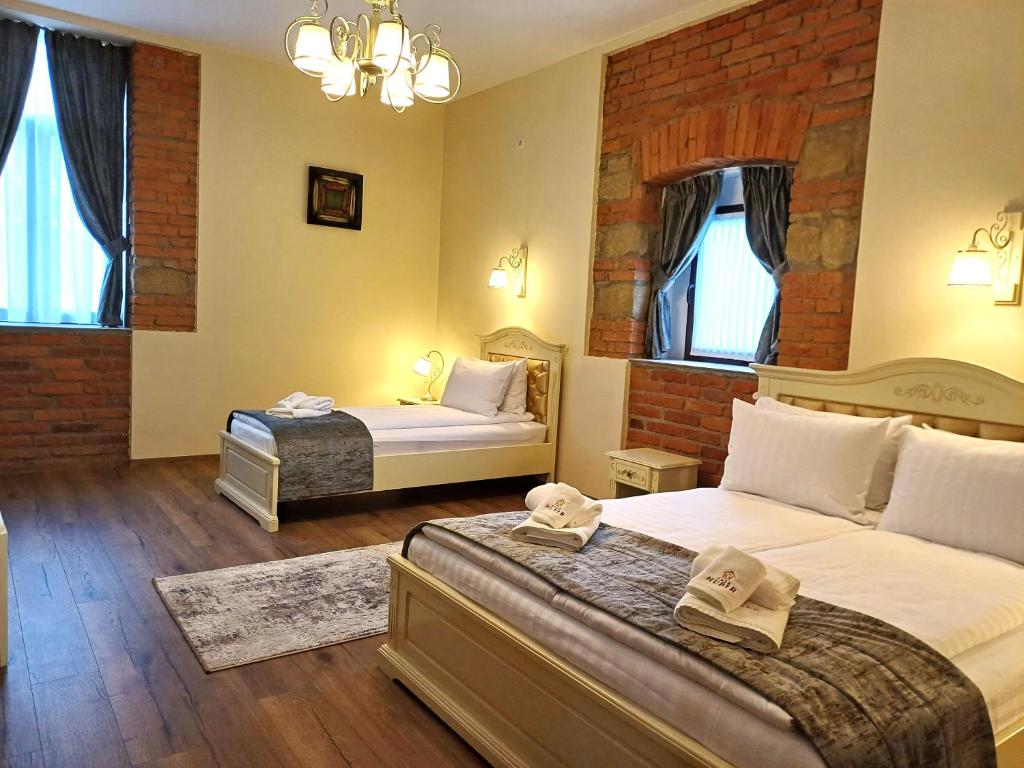 锡盖图马尔马切伊Casa Huber的一间卧室设有两张床和砖墙