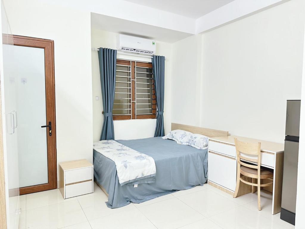 河内nha7bngo140tdh的一间卧室配有一张床、一张书桌和一个窗户。