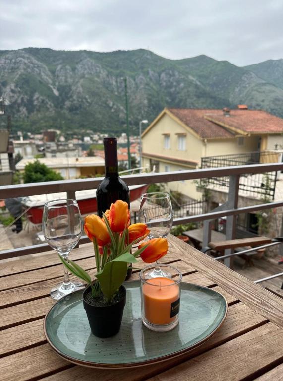 科托尔Club Themis Hotel的桌上放有一瓶葡萄酒和鲜花的盘子