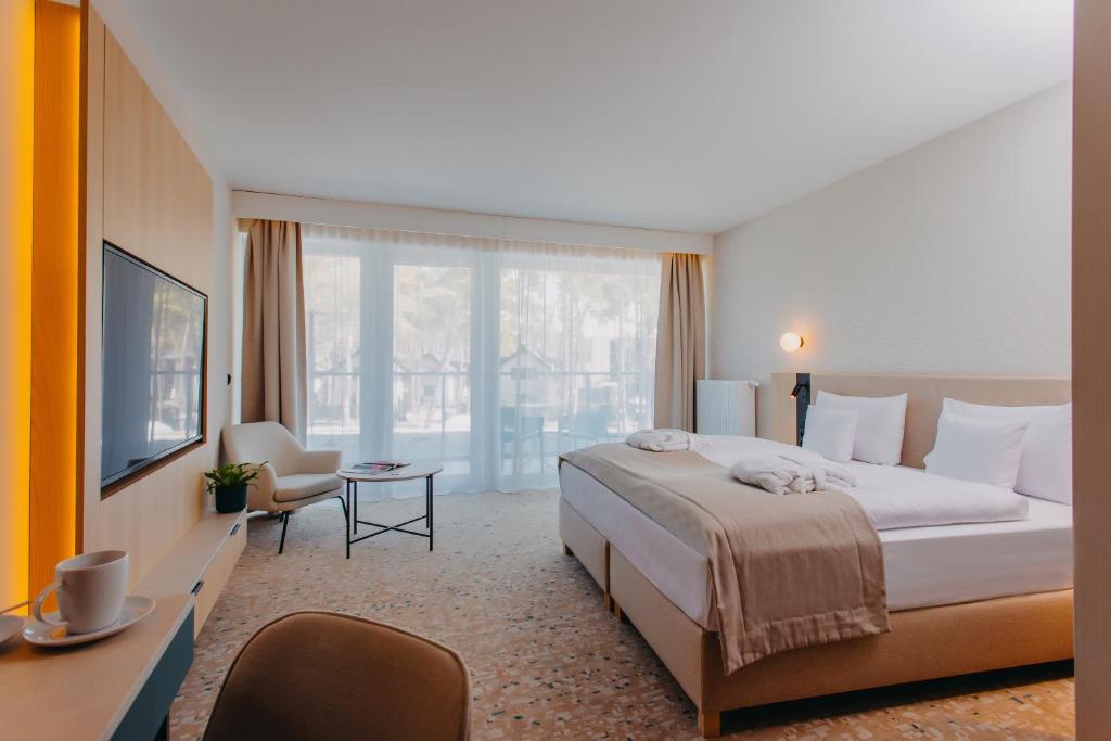 波别罗沃Hotel Linea Mare的酒店客房设有一张床和一个大窗户