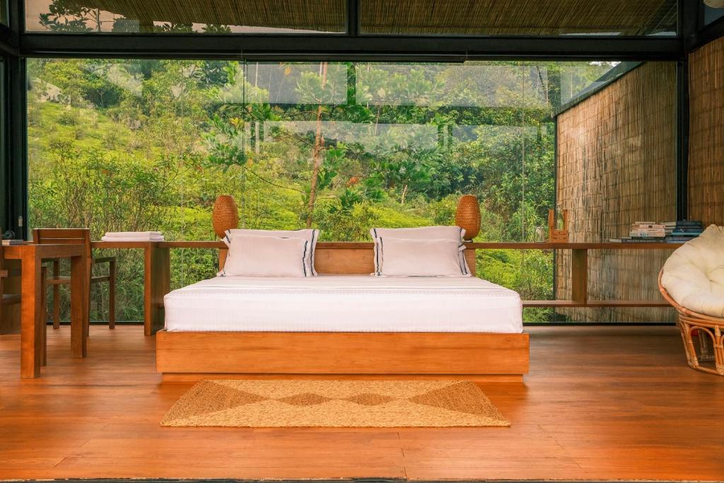 KalawanaKurunduketiya Private Rainforest Resort的一张位于带大窗户的房间内的床铺