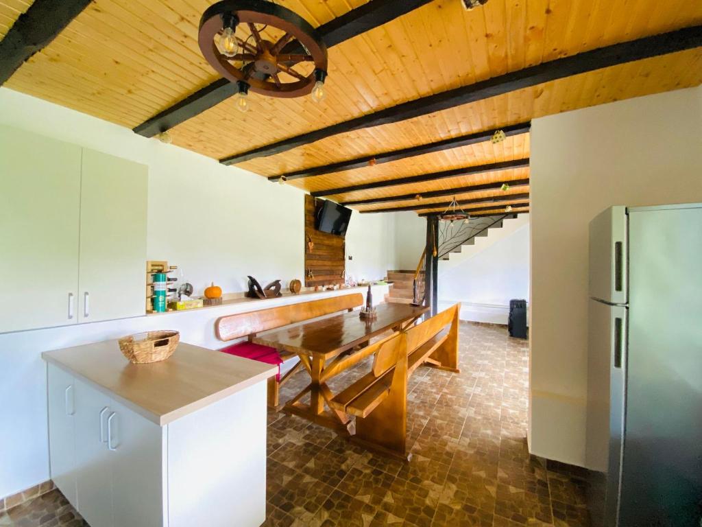 伦库Serenity Garden Villa的厨房设有木制天花板、桌子和冰箱。