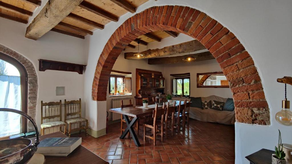特拉西梅诺湖畔托罗Casale Alcinoo - Rustico的房屋内的厨房和用餐室,配有拱门