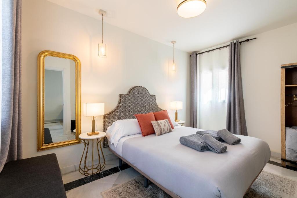 塞维利亚Arco de la Seda - Hotel Boutique的一间卧室配有一张大床和镜子