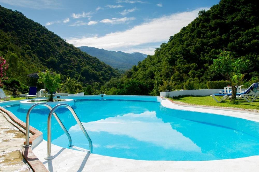 埃尔博斯克Finca El Huertezuelo的一座蓝色的游泳池,后面是群山