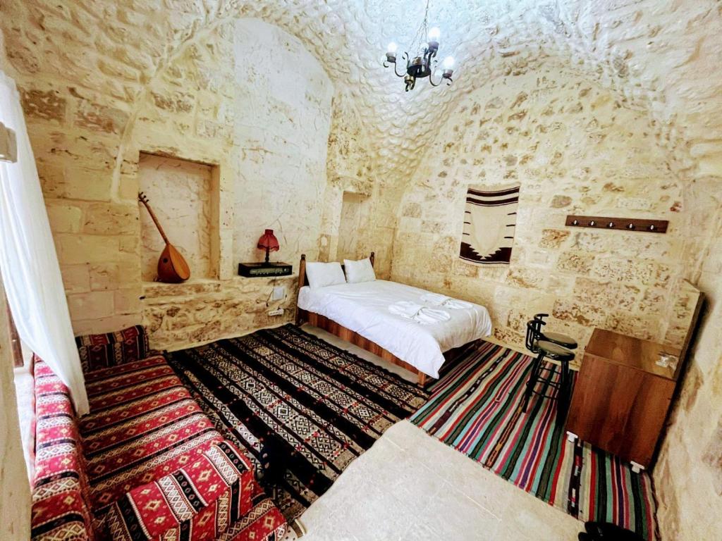 尚勒乌尔法Zininur boutique hotel的卧室配有一张石墙床