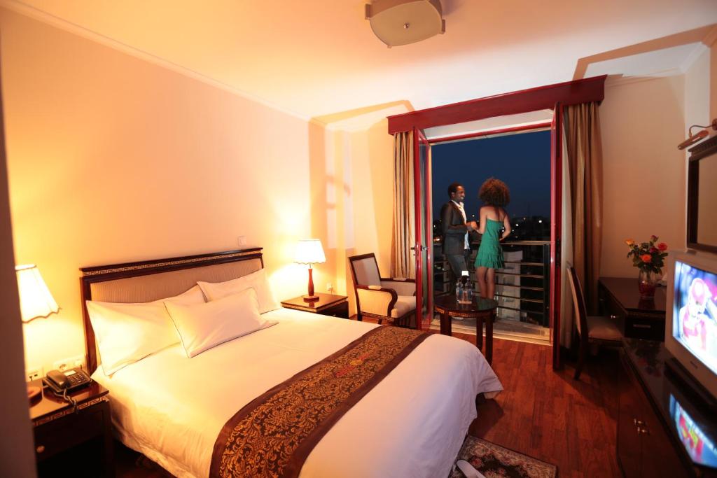 亚的斯亚贝巴Wassamar Hotel的酒店客房设有床、电视和女性