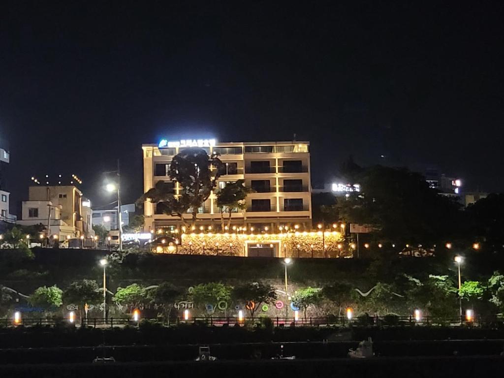西归浦市천지연크리스탈 하버39호텔的一座建筑,在晚上有灯