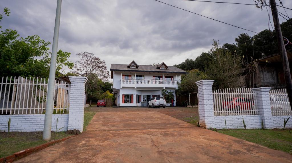 Puerto LibertadHotel Puerto Libertad - Iguazú的前面有栅栏的白色房子
