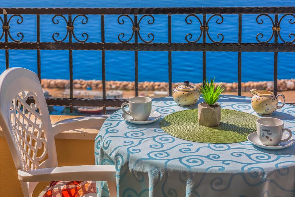 伯德古拉古德耶公寓的一张桌子,上面有杯子和碟子,享有海景