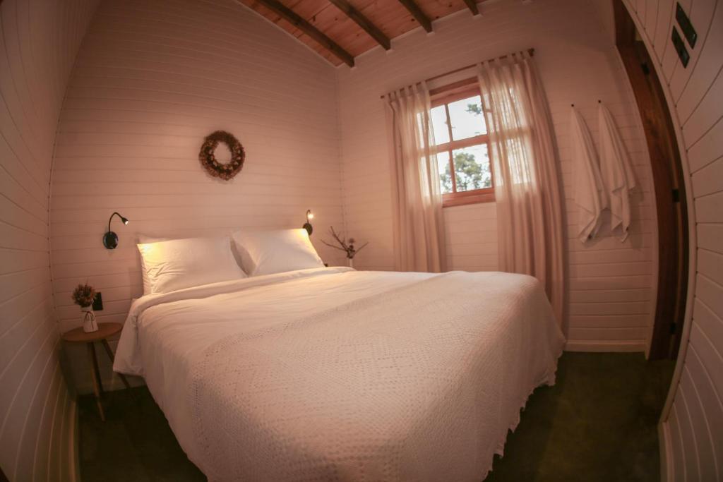 乌鲁比西Skyline Urubici - Barn的卧室配有白色的床和窗户。