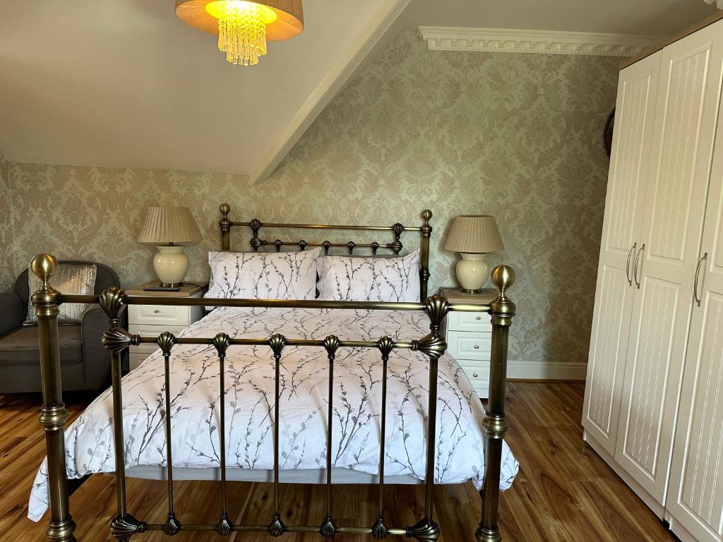 伯恩茅斯ElMurrs的一间卧室配有一张带两盏灯和吊灯的床。