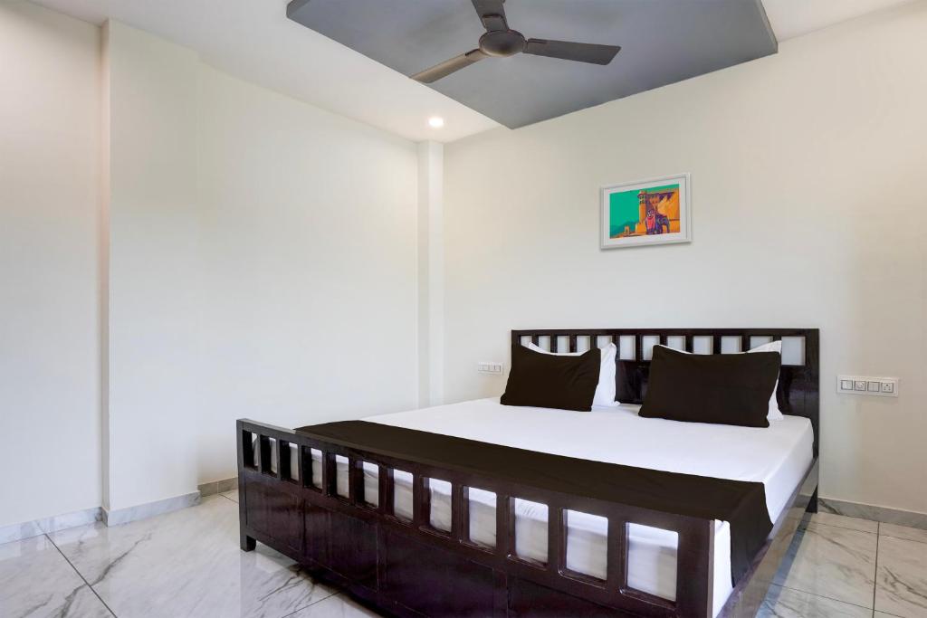 巴罗达OYO Hotel Ambika的一间卧室配有一张带吊扇的床
