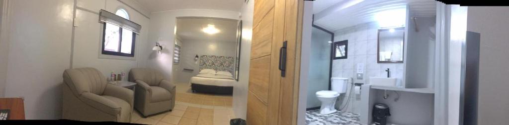 SinabacanSunbloom Beachfront Hotel and Restaurant的一间带水槽的浴室和一间带床的房间