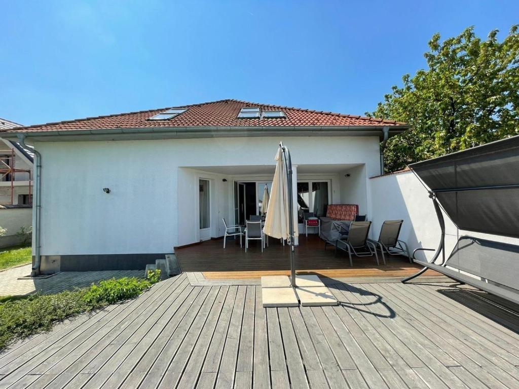 费尔特德Freistehendes Ferienhaus mit Swimmingpool, Kamin, Internet, unweit Neusiedlersee的一个带遮阳伞和房子的庭院