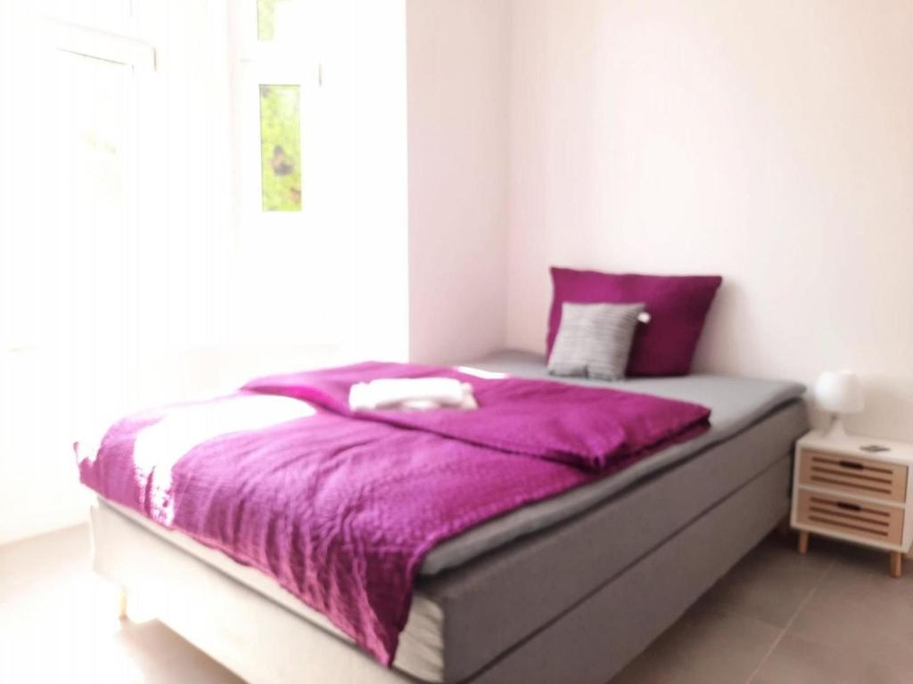 桑德Villa Mariensiel 1OG li的卧室里一张带紫色毯子的床