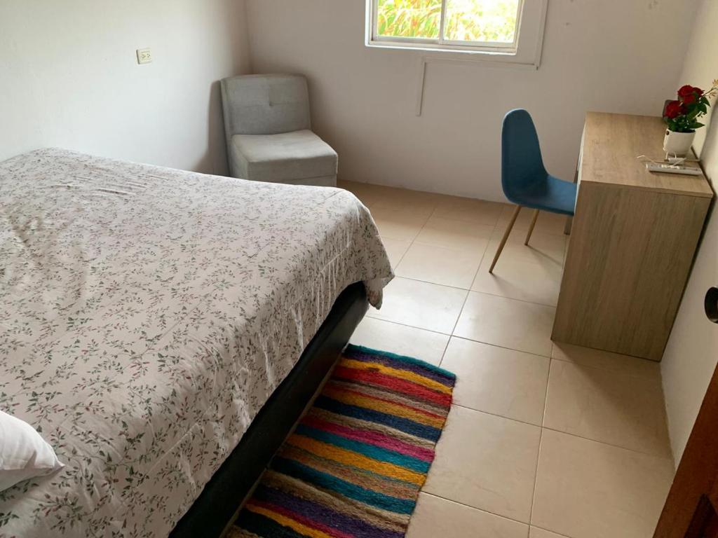 Puerto SalgarAcogedor Apartamento 2 alcobas cerca al mar的一间卧室配有一张床、一张桌子和一把椅子