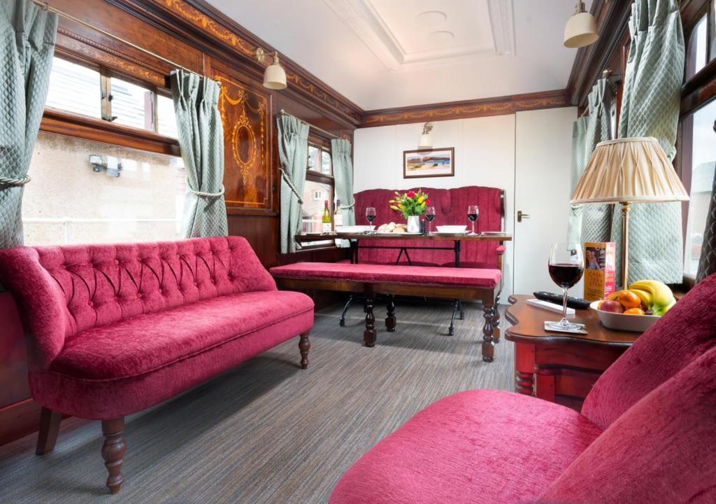 雷文格拉斯Irt Pullman Carriage的客厅配有红色的沙发和桌子