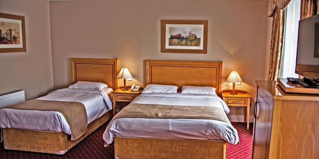 巴利纳斯洛吉伦的酒店的酒店客房设有两张床和两盏灯。