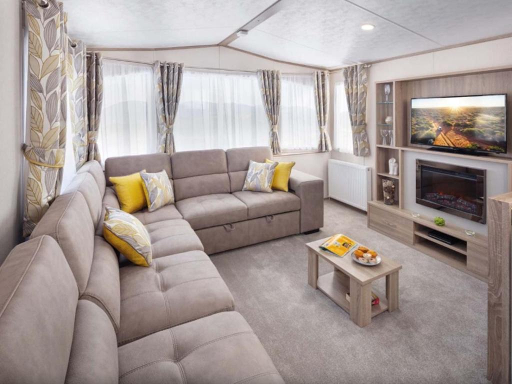 坎伯利SBL38 Caravan at Camber Sands - quiet location的带沙发和电视的客厅