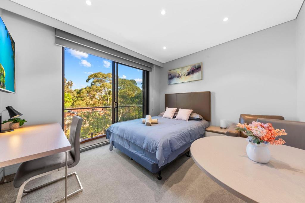 悉尼Nice and quite studio Roseville的一间卧室配有一张床、一张桌子和一张桌子