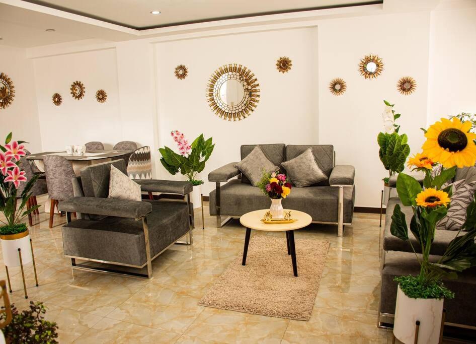 库斯科Departamento Familiar Alado del aeropuerto的带沙发、桌子和鲜花的客厅
