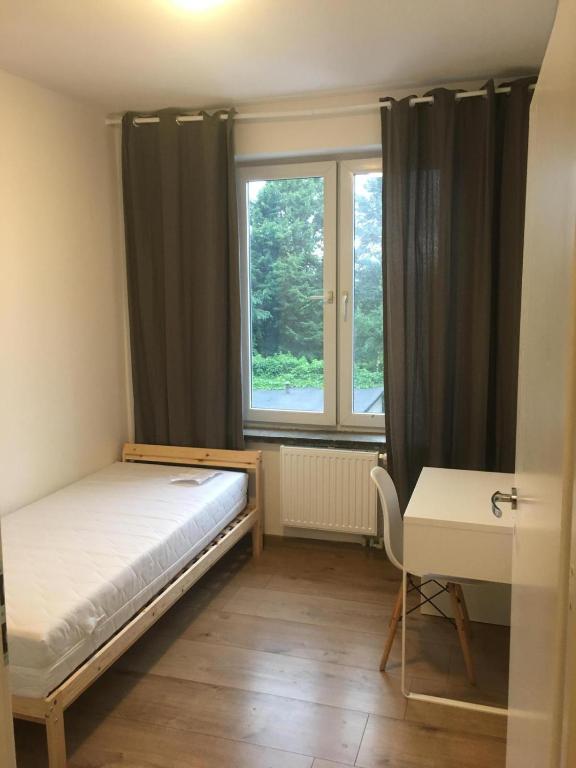 弗罗茨瓦夫Hallera Wroclaw的一间卧室配有一张床、一张书桌和一个窗户。