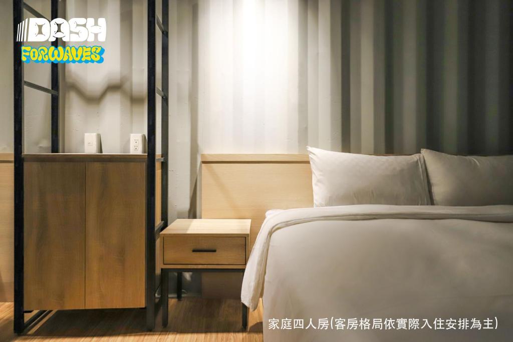 Hsin-hsing達煦浪花旅店的卧室配有一张床,床头柜位于床边。