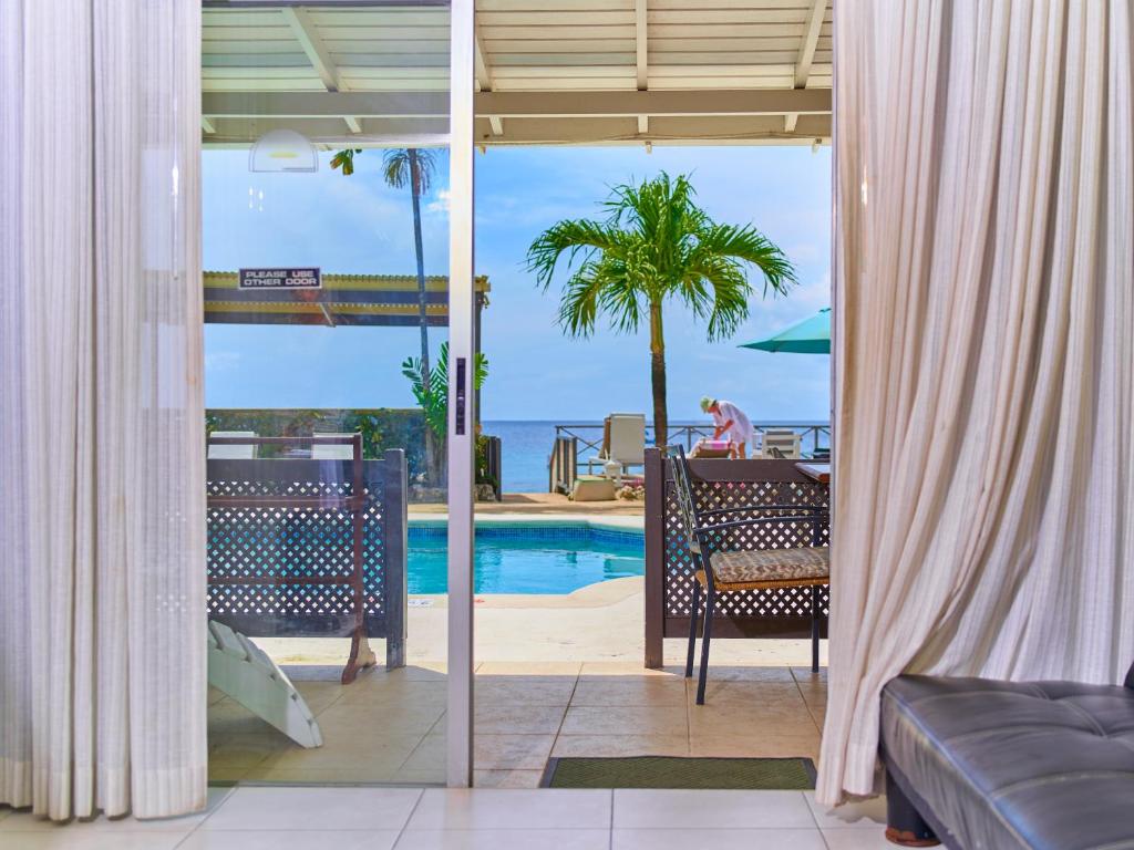 圣詹姆斯热带日落海滩公寓式酒店的客房享有游泳池和海洋的景致。