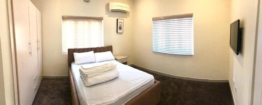 莱基Portland Residence的小卧室配有带白色床单和枕头的床