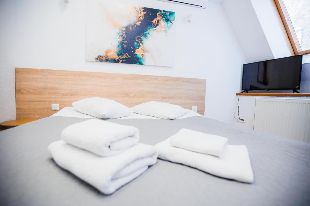 利沃夫斯达伊哈尔科夫酒店的一张白色的床,上面有三条白色毛巾