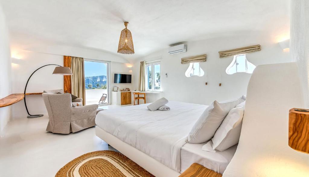 伊斯基亚Villa Ravino Secret Retreat的白色卧室配有一张大床和椅子