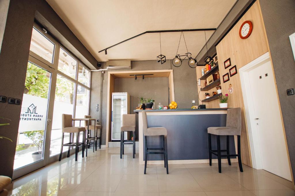 斯特鲁米察Urban Studio Apartments的厨房以及带吧台和凳子的用餐室。