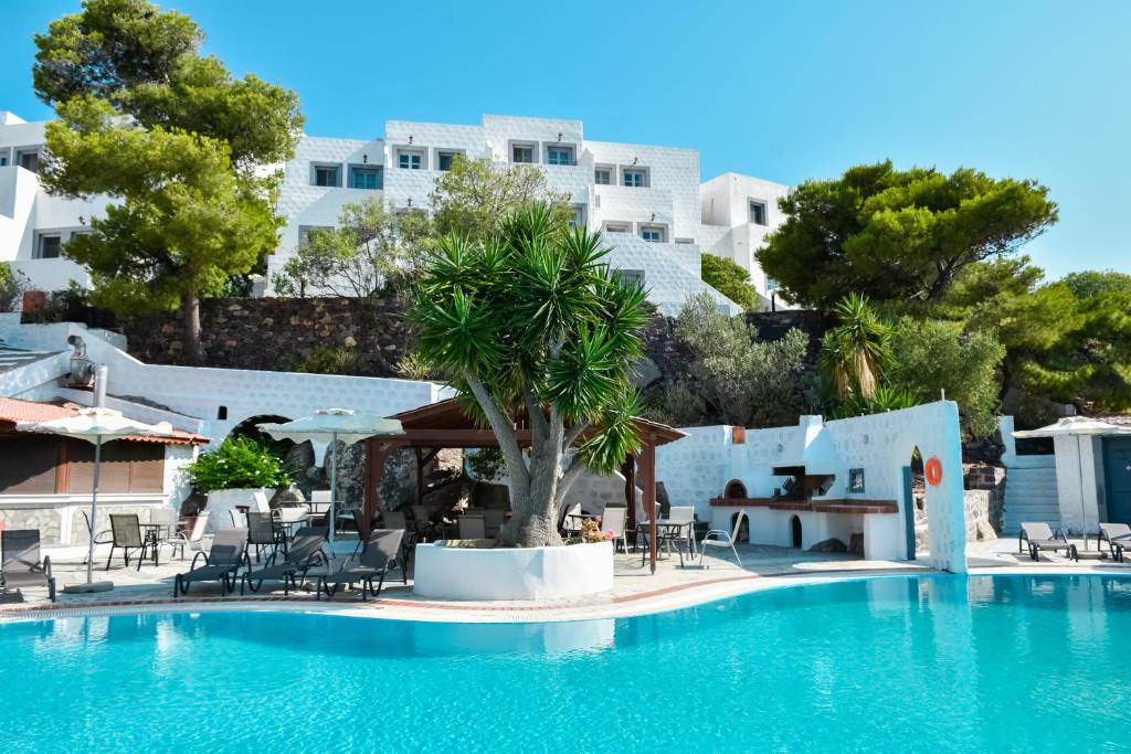 斯科拉Anamar Patmos的酒店游泳池设有桌椅
