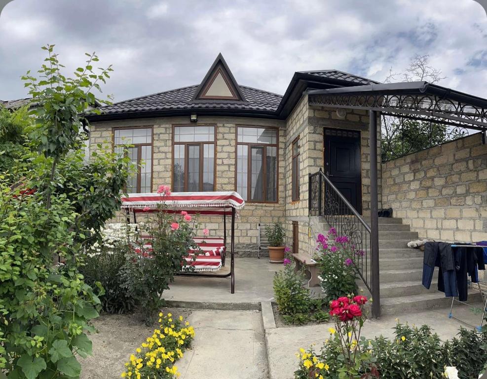 库萨雷Halal House VİP的砖屋,有门廊和一些花