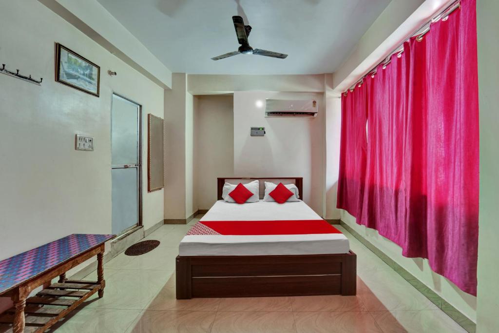 巴特那OYO Flagship Hotel CDS Regency的一间卧室配有床和红色窗帘