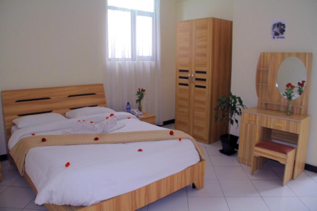 Debre ZeyitEkshesh Hotel Bishoftu的一间卧室配有一张大床和镜子