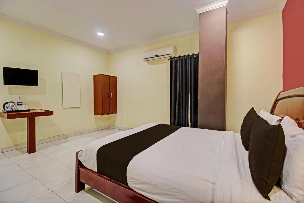 海得拉巴Hotel Ruma Near Nampally Railway Station的一间卧室配有一张床和一张书桌