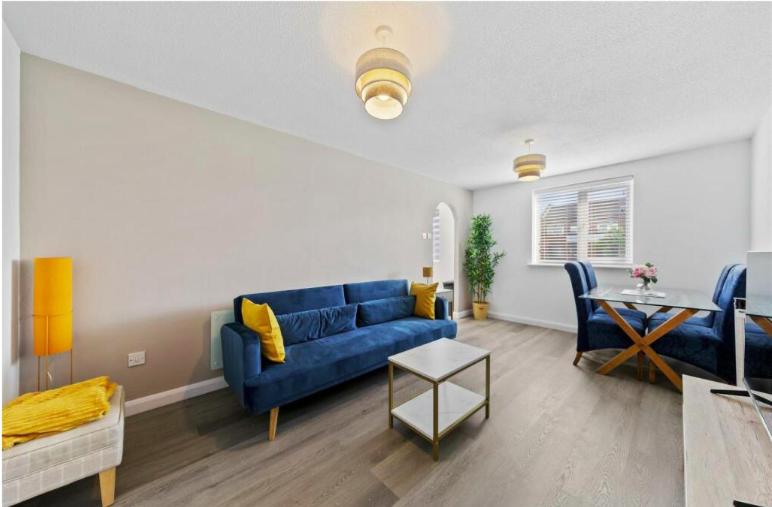北安普敦Stylish 2 bedroom Apartment in Kettering Town Centre, sleeps 4, free parking, wifi, Sky, Netflix的客厅配有蓝色的沙发和桌子