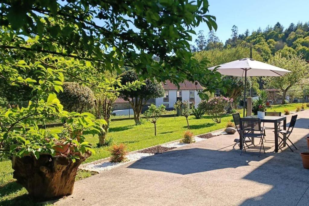 内格雷拉Casa América的庭院配有遮阳伞和桌椅。
