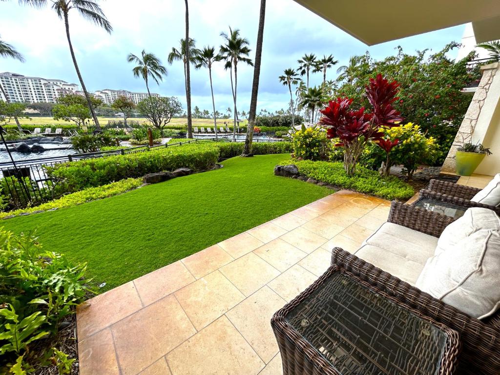卡波雷Ground floor unit with Private Garden的庭院设有草坪,种植了长凳和棕榈树