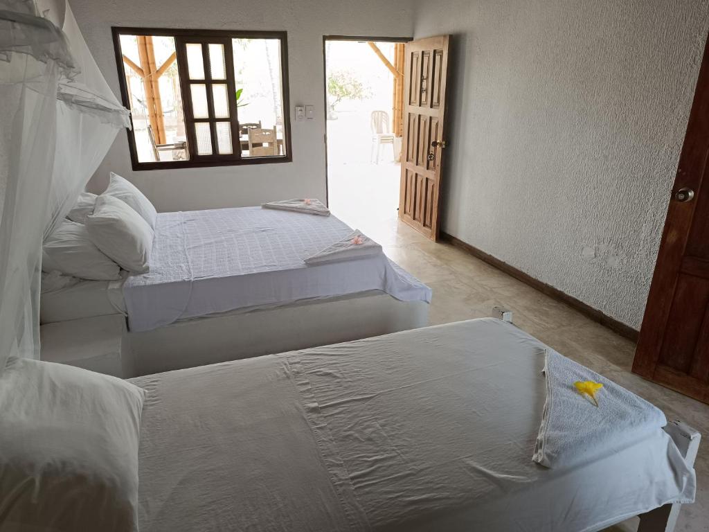 GuachacaSierra Sagrada Tayrona的客房设有两张床和窗户。