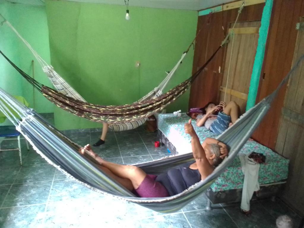 马瑙斯Quarto compartilhado e camping na floresta的躺在镜子前的吊床上的女人