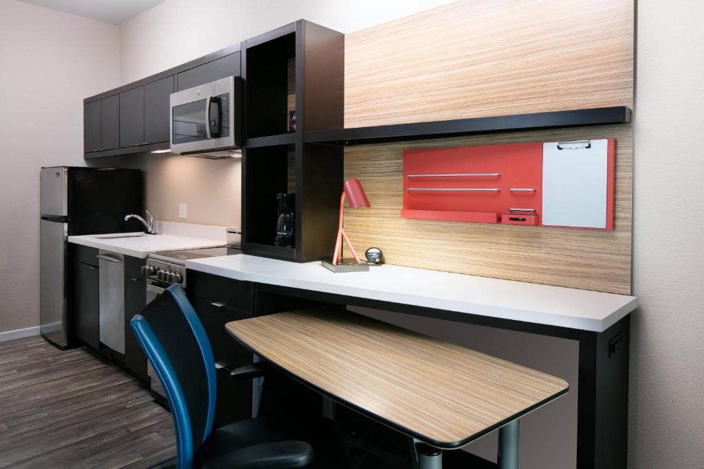 堪萨斯城TownePlace Suites by Marriott Kansas City Airport的厨房配有柜台和桌椅