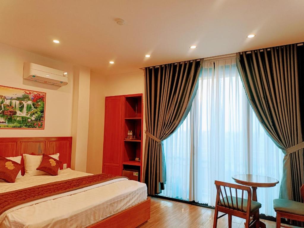 顺化PHƯƠNG ĐÔNG HUẾ HOMESTAY的一间卧室配有一张床、一张桌子和一个窗户。